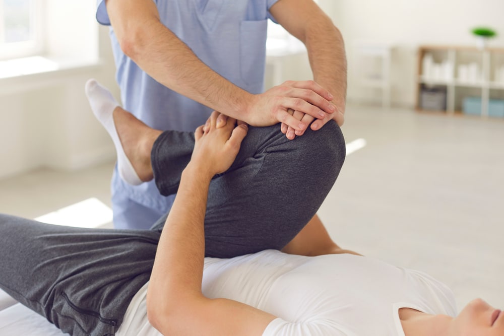 Chiropractor treating patient with knee pain