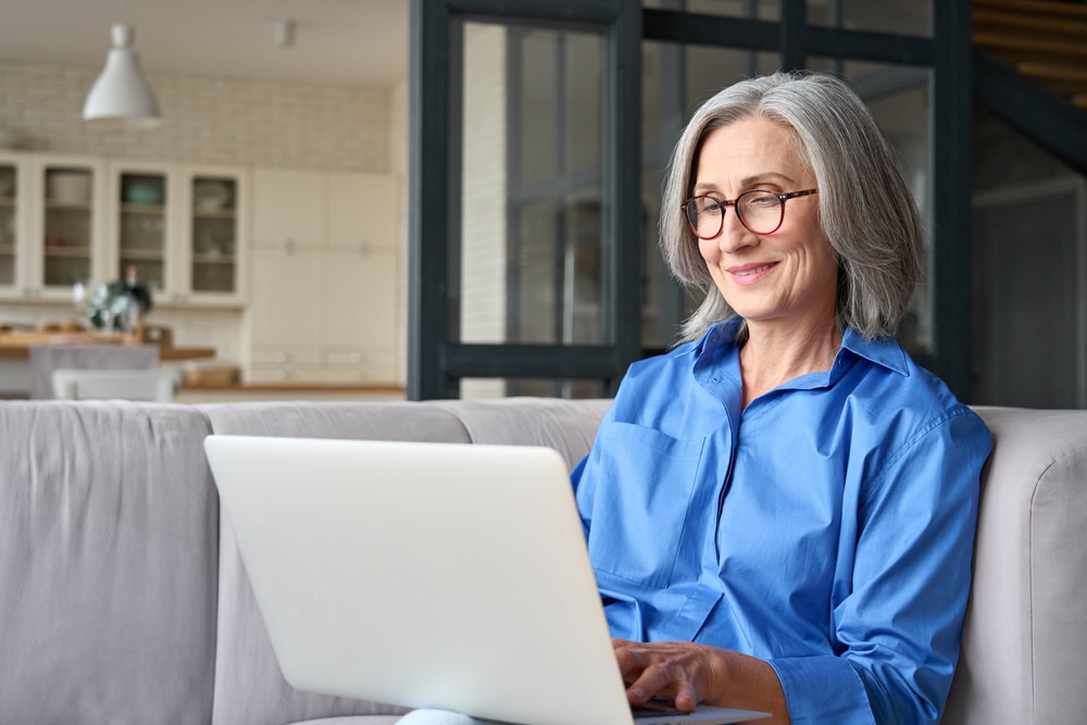 Older woman using laptop on couch