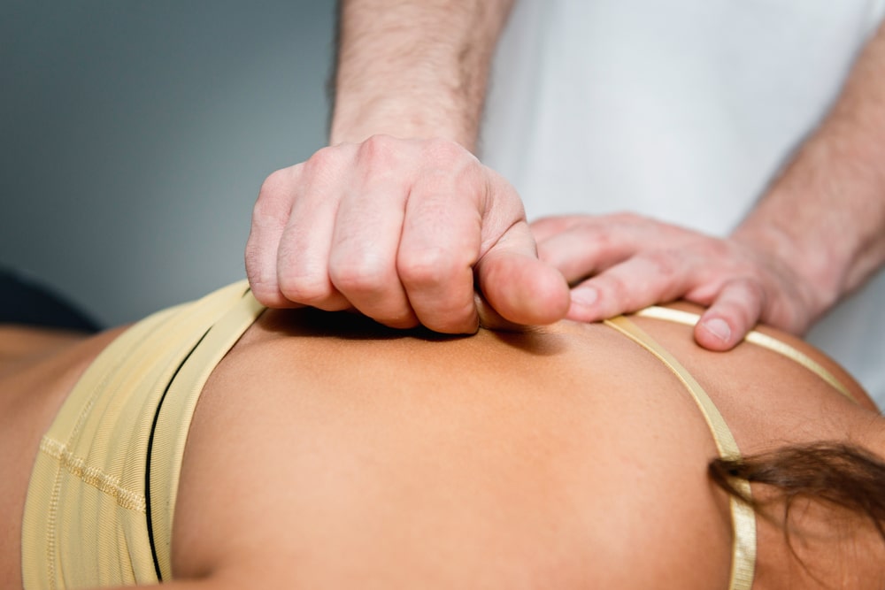 Woman receiving chiropractic treatment on back