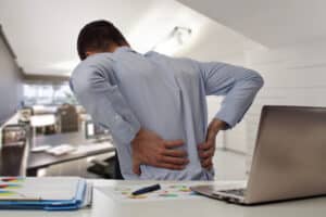 Man with back pain in office