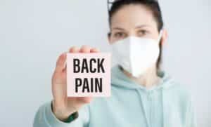 Woman holding sign saying back pain