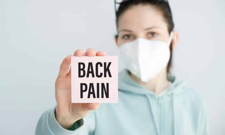 Woman holding sign saying back pain