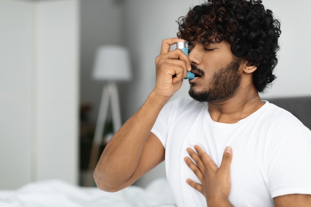 Man using asthma inhaler